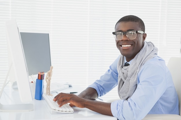 Hipster glimlachende zakenman die bij zijn bureau werkt