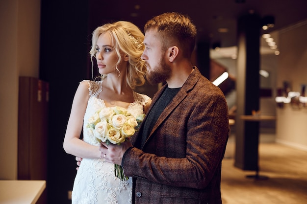 Hipster groom and the bride, love and loyalty. Couple in love hugs and kisses on their wedding day. Ideal couple is preparing to become husband and wife