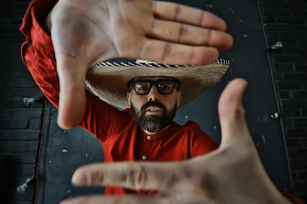 hipster guy in glasses with a gray beard in a hat with brim. emotionally posing model man