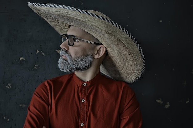 хипстерский парень в очках с седой бородой в шляпе с полями. эмоционально позирующий модельный мужчина