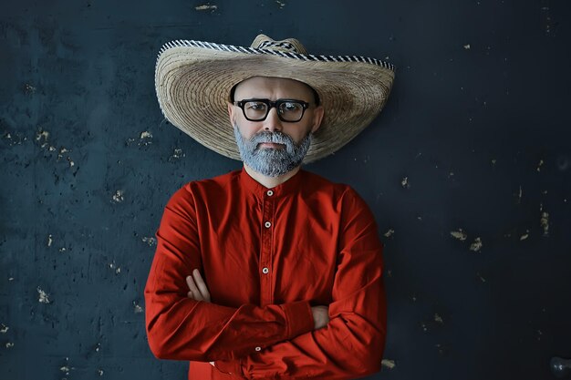 hipster guy in glasses with a gray beard in a hat with brim. emotionally posing model man