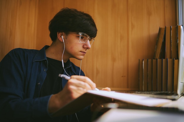 hipster guy with glasses watching a training webinar on a laptopdistance learning online training