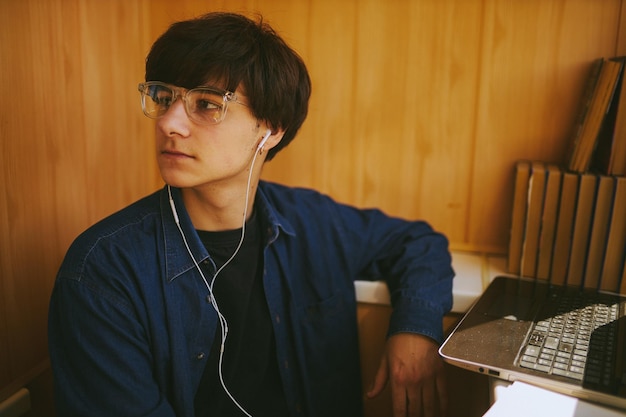 hipster guy with glasses watching a training webinar on a laptopdistance learning online training