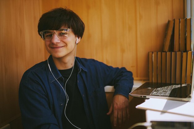 Ragazzo hipster con gli occhiali che guarda un webinar di formazione su un laptopformazione online di apprendimento a distanza