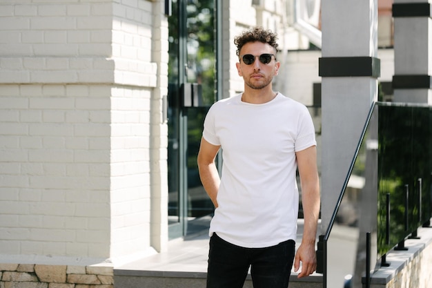 Photo hipster handsome male model wearing white blank tshirt with space for your logo or design in casual urban style