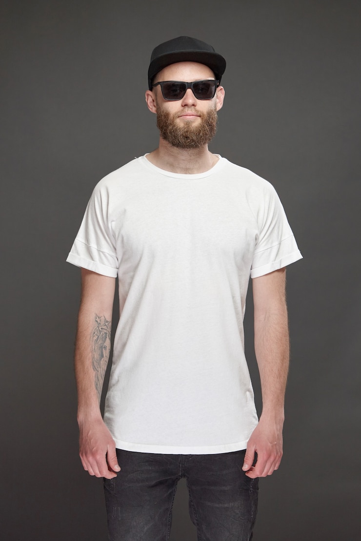 Photo hipster handsome male model with beard wearing white blank t-shirt and a baseball cap with space for your logo or design in casual urban style