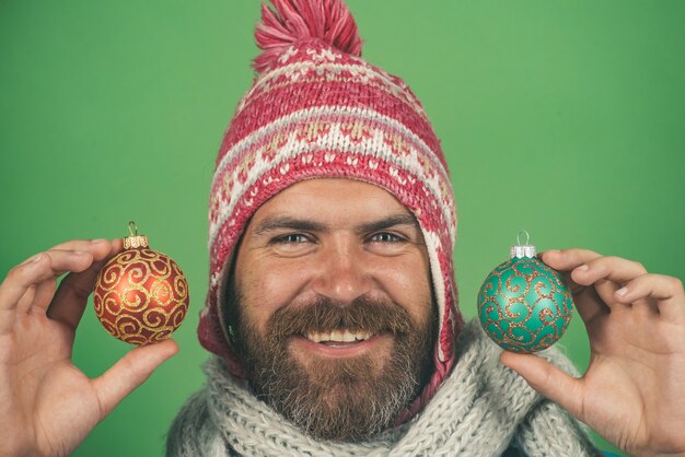 Hipster happy smile in winter hat and scarf with christmas balls new year and christmas celebration