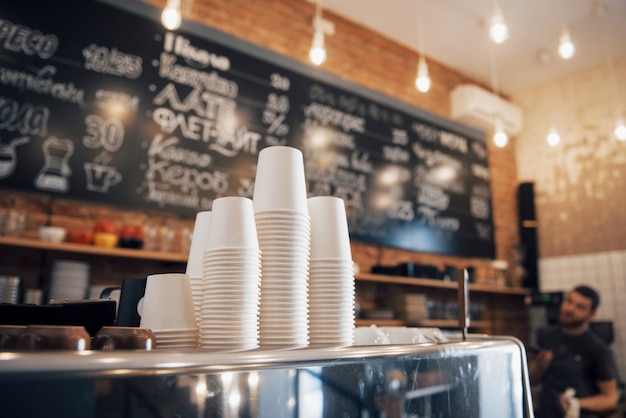 Caffetteria dall'aspetto hipster pronta per essere aperta al giorno con un bancone pulito e ordinato e una macchina da caffè lucida ben mantenuta sulla superficie in legno