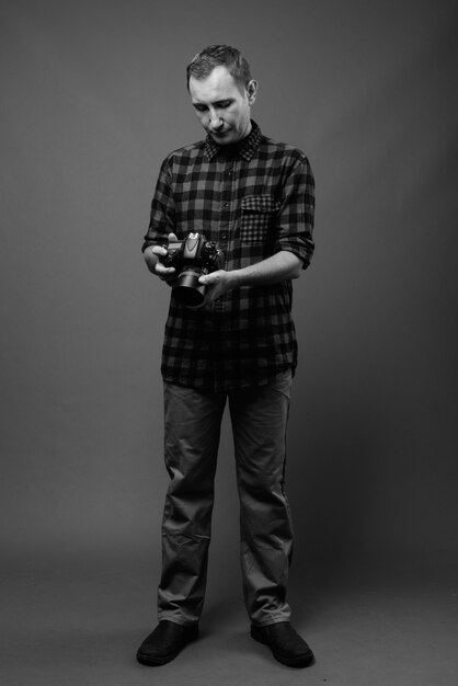 hipster man against gray wall in black and white