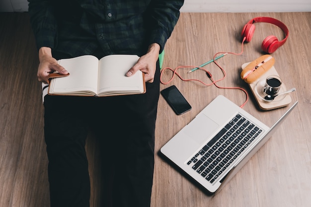 Hipster man hands holding notebook at home 