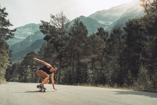 Hipster man lang instappen op een bochtige bergweg