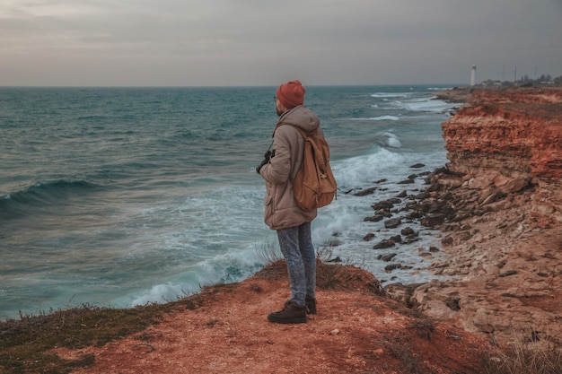 The hipster man looking to lighthouse in seaside