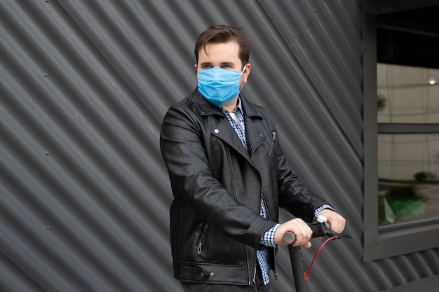 Hipster man met medische masker op elektrische scooter