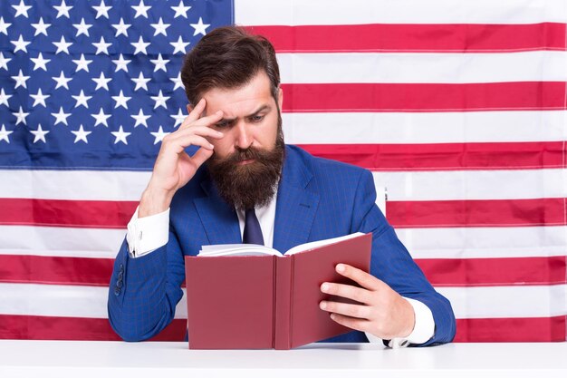 Hipster man reading book USA flag background learning law concept