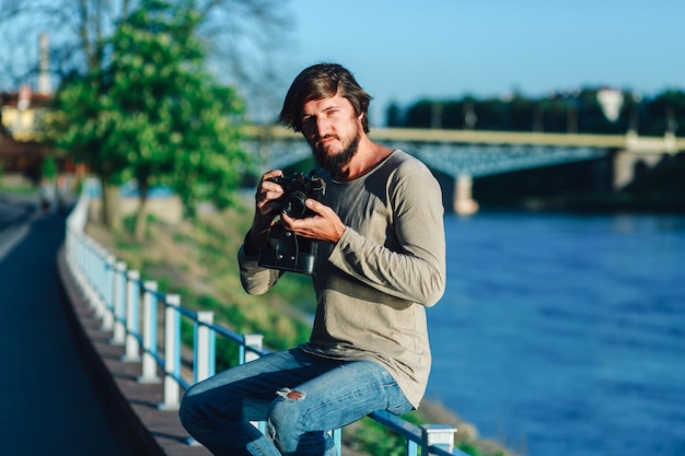 Hipster man schoot fotografie van hem filmcamera op straat publiek