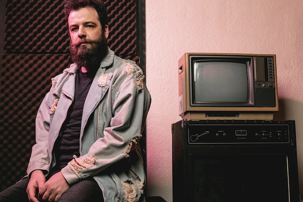 Hipster man siting next to vintage tv