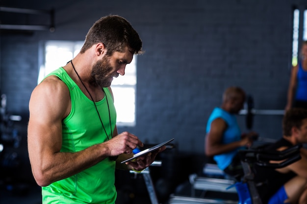 Hipster man using tablet in gym