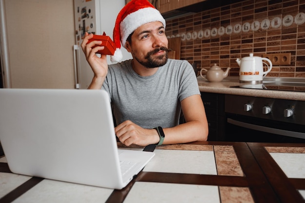 A hipster man with a red cup sitting at home at Christmas time