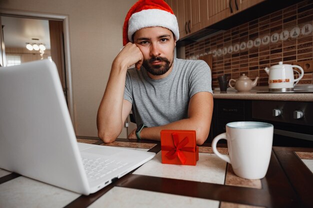 A hipster man with a red cup sitting at home at Christmas time