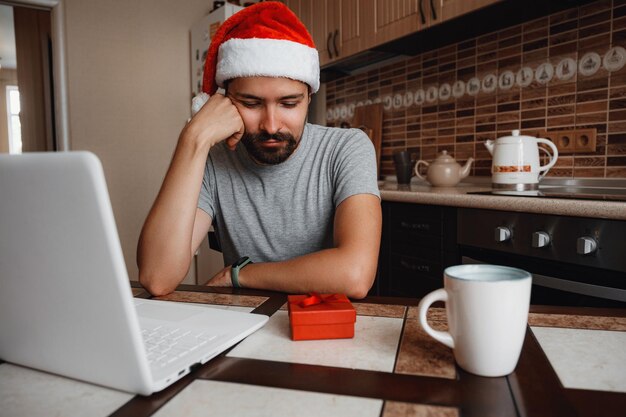 A hipster man with a red cup sitting at home at Christmas time