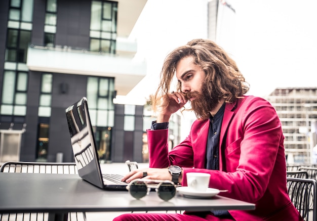 Uomo dei pantaloni a vita bassa che lavora al computer