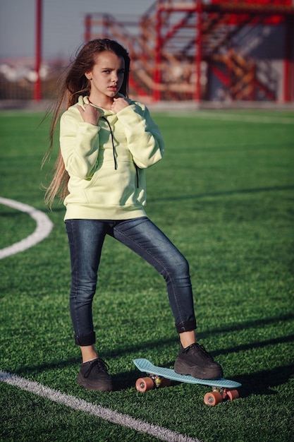 Hipster meisje met skateboard buitenshuis modern meisje met een skateboard dat op een stadion loopt rust van studie outdoors lifestyle