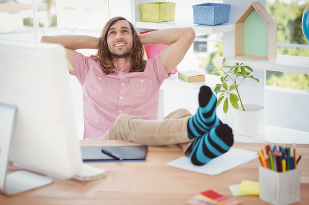 Foto hipster ontspannen met de benen op het bureau
