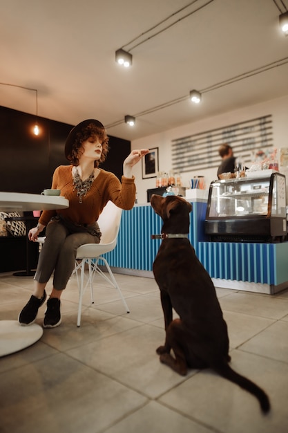 Hipster op een wandeling met zijn hond ging naar een café om koffie te drinken