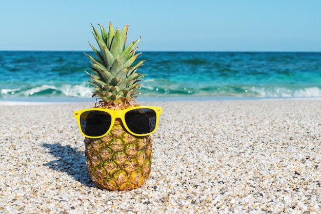 Hipster pineapple in sunglasses on the beach