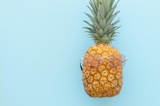 Hipster pineapple with sunglasses against a blue background