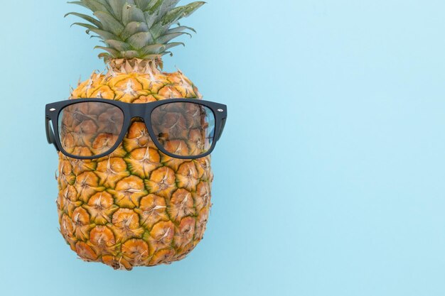 Hipster pineapple with sunglasses against a blue background