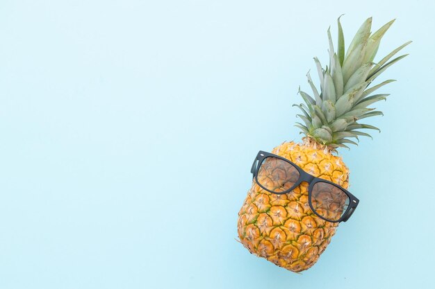 Hipster pineapple with sunglasses against a blue background