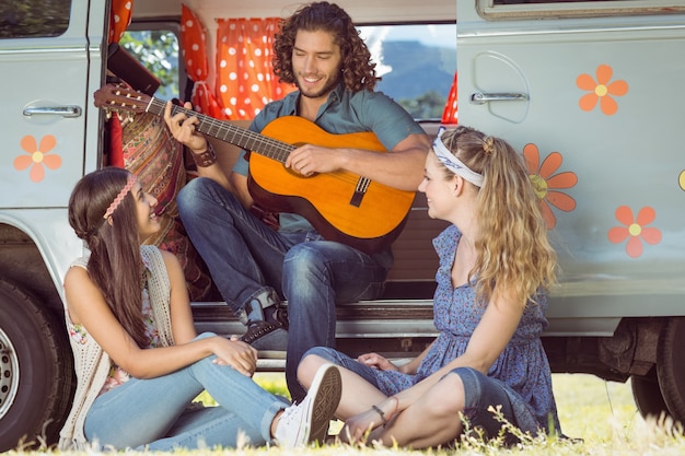 Hipster che suona la chitarra per le ragazze