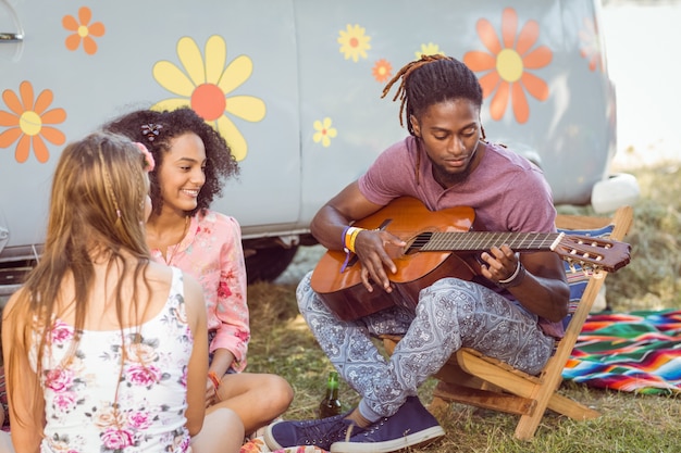 Hipster playing guitar for his friends 