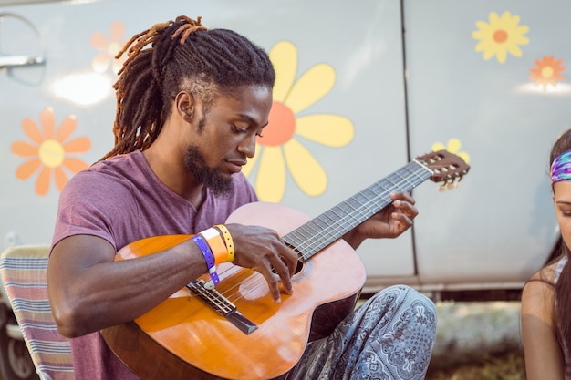 Hipster playing guitar for his friends 