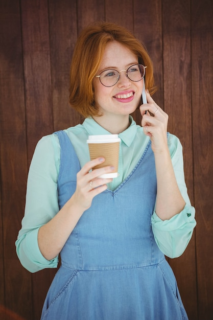 Hipster praten over telefoon met koffie