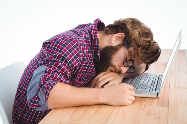 Hipster resting with head on laptop