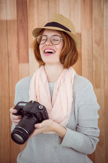 Hipster smiling and holding camera