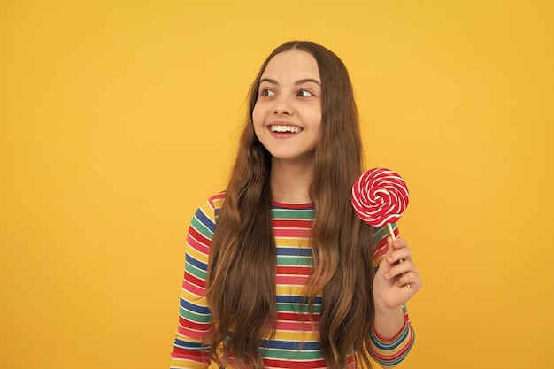 Hipster teenager child girl lick lollypop sugar nutrition candy and sweets child eat lollipop popsicle