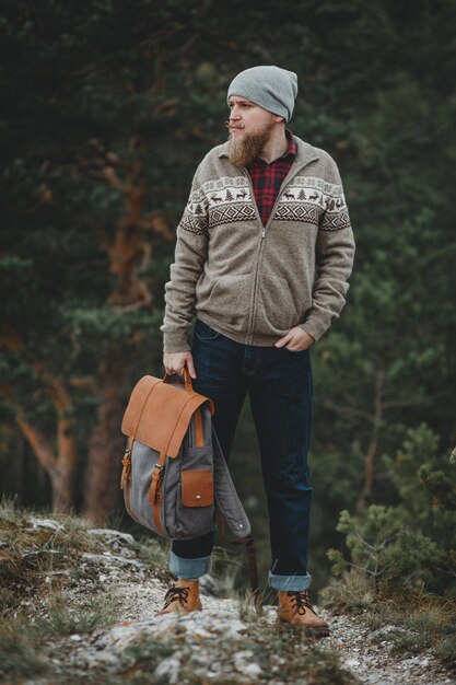 Photo hipster traveler with vintage backpack in nature