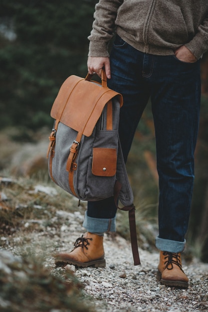 Hipster traveler with vintage backpack in nature