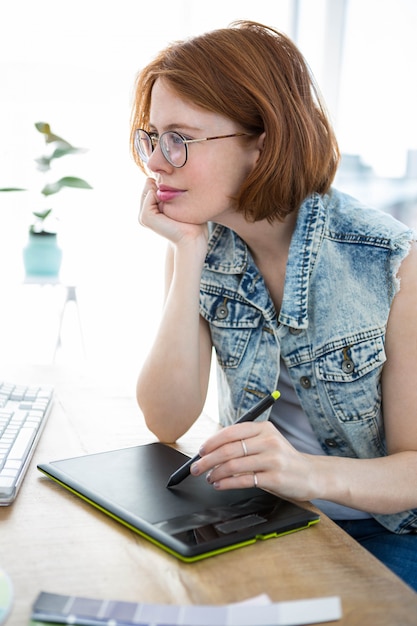 hipster vrouw aan haar bureau, schrijven op een digitale tekening taablet