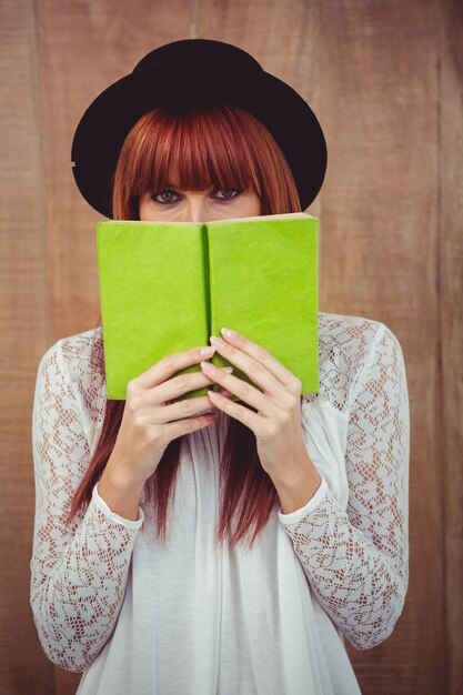 Hipster vrouw achter een boek