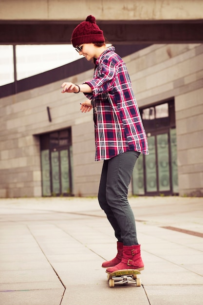 Hipster vrouw in casual outfit skateboarden in de stad