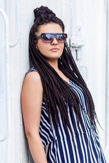 Hipster vrouw poseren in de buurt van witte muur