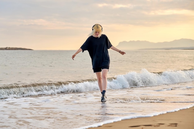 Hipster vrouwelijke tiener plezier op het strand bij zonsopgang