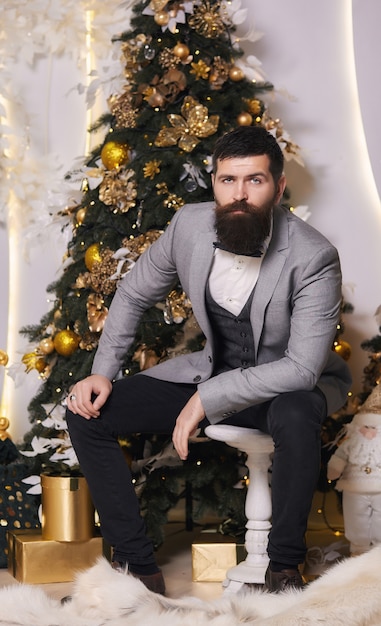 The hipster waiting for a Christmas party.Bearded man in gray classic suit having luxury style