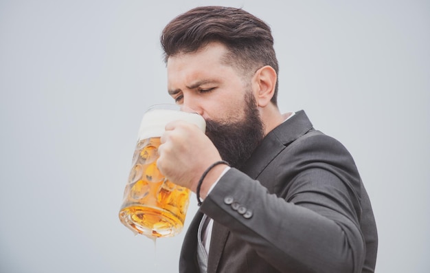Фото Хипстер с бородой и усами в костюме пьет пиво после рабочего дня германия бавария пиво время рука