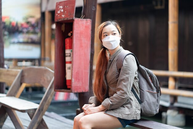 Hipster woman traveler with mask and backpack sitting relax in trip
