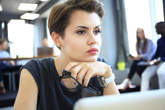 Hipster woman use laptop enorme loft studio.student researching process work.young business team working creative startup modern office.analyze market stock, new strategy.blurred, film effect.